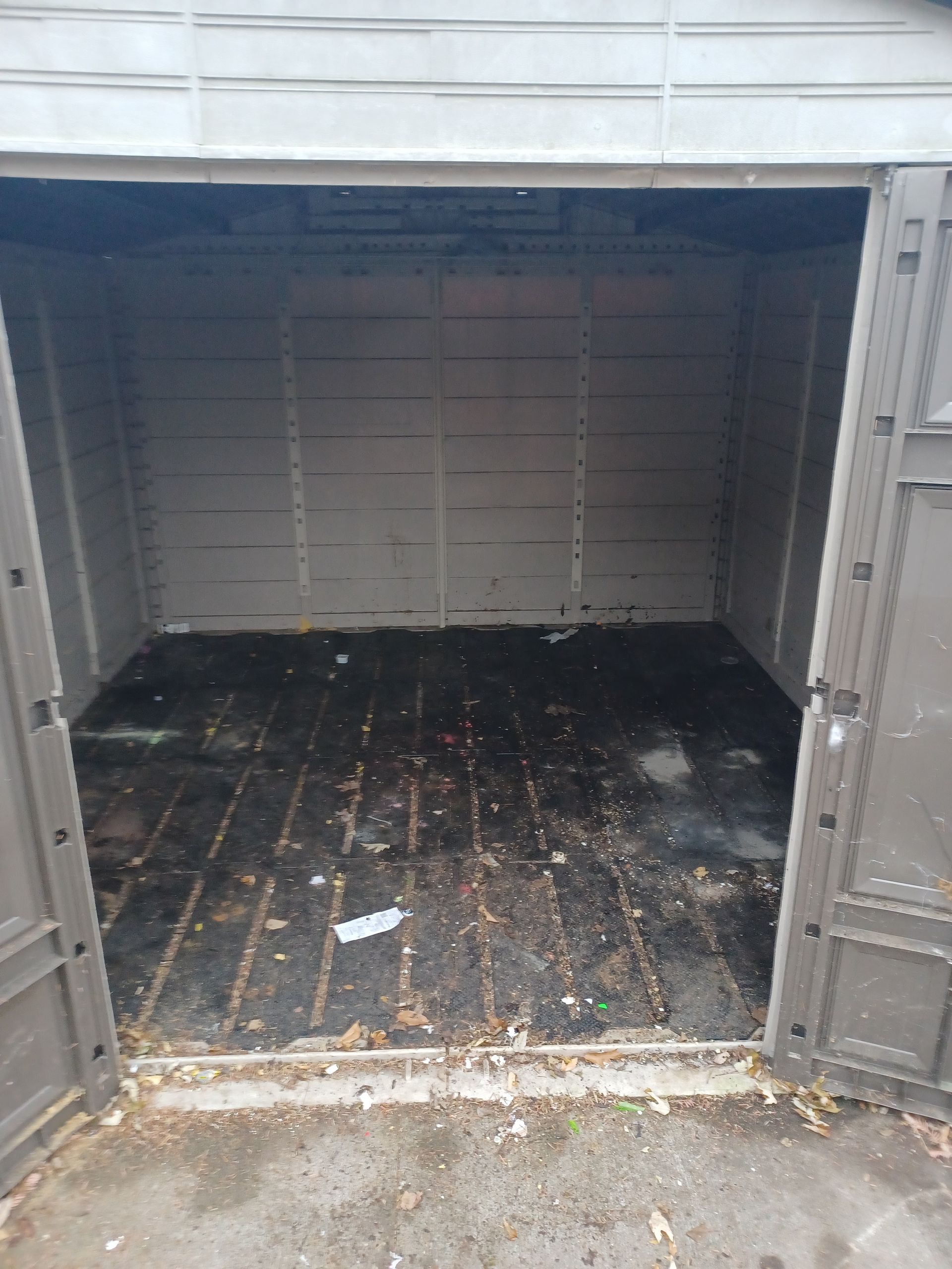 The inside of an empty shed with the doors open.
