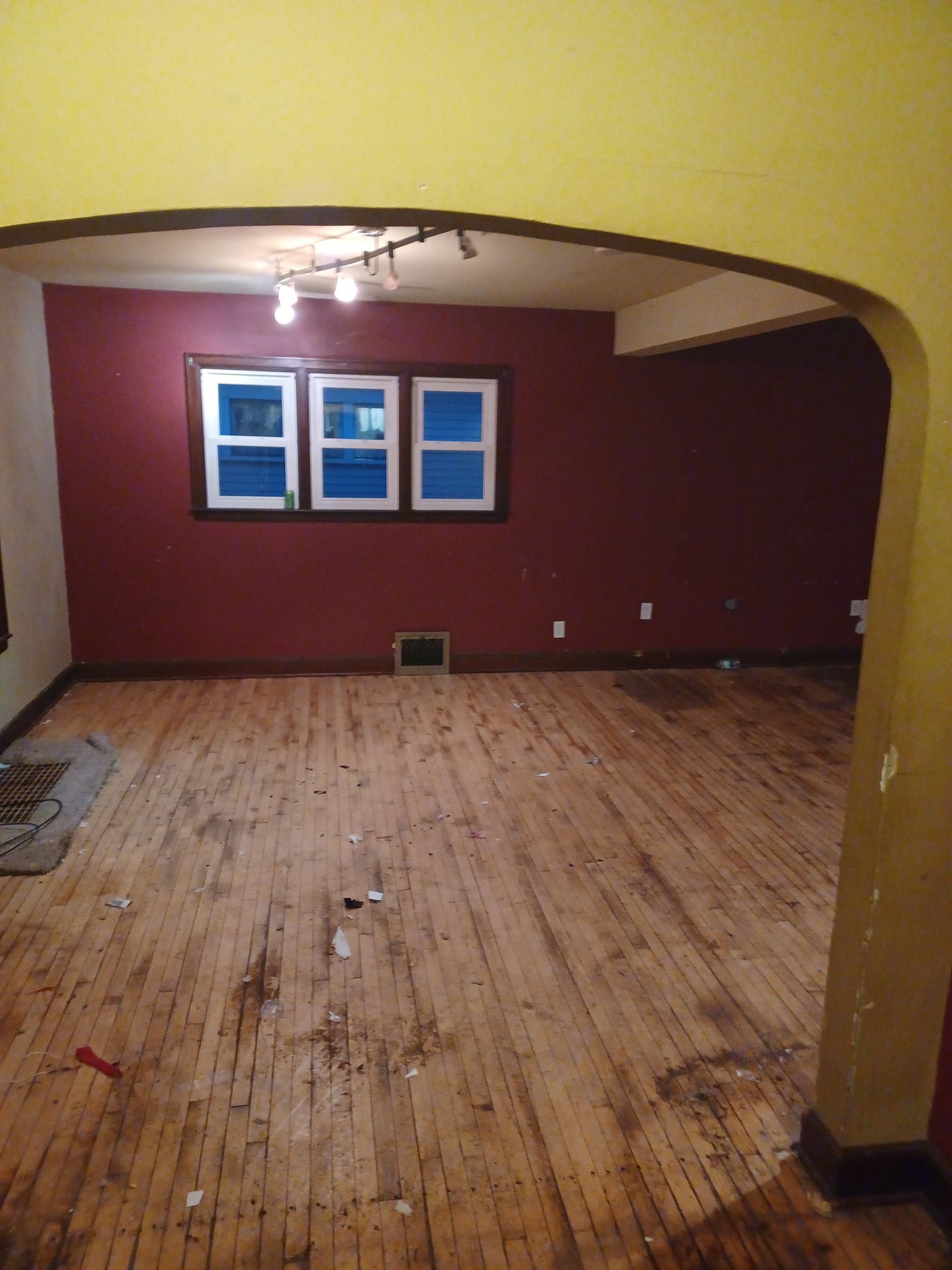 An empty room with a wooden floor and red walls