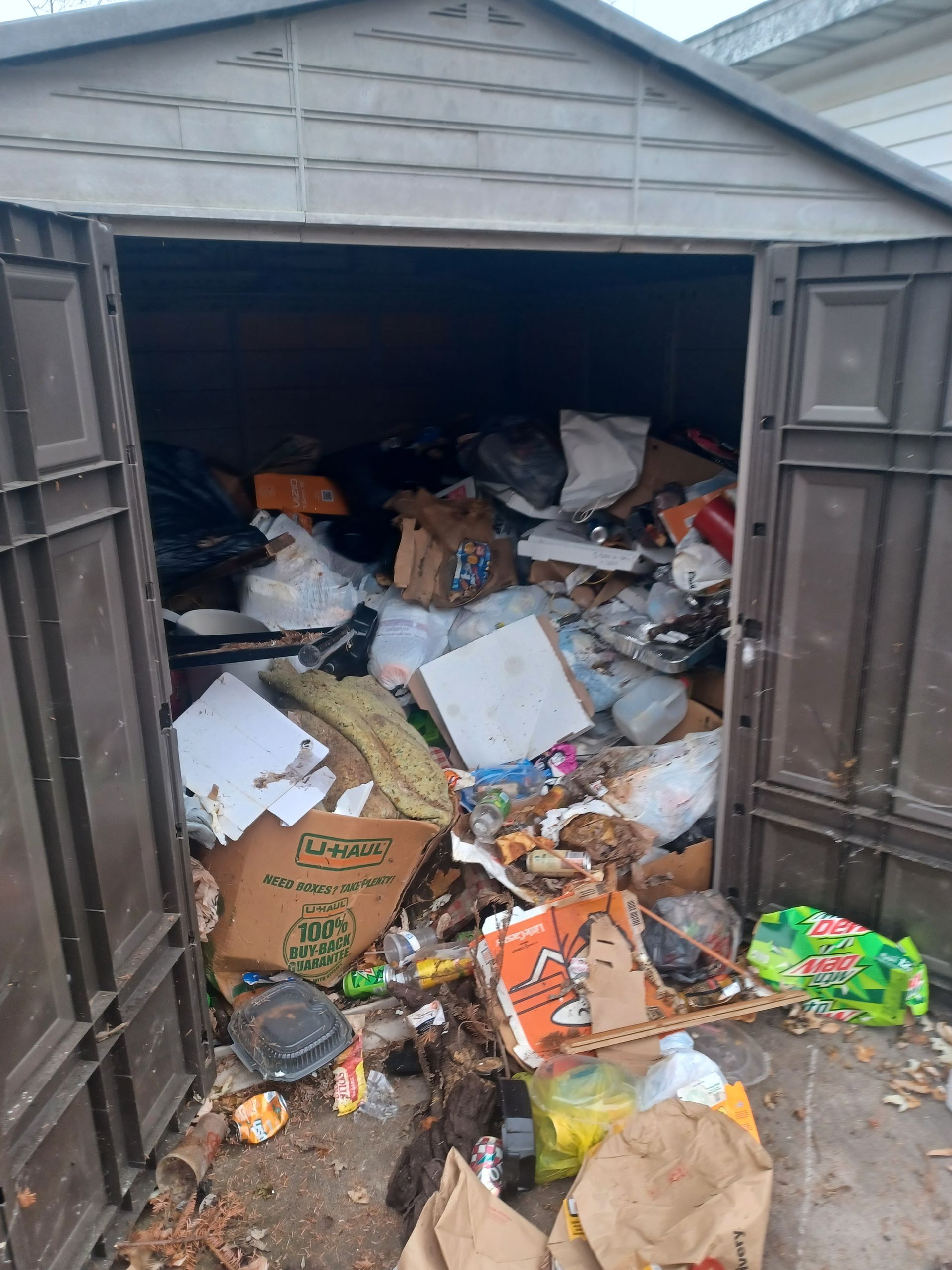 A garage filled with lots of trash and junk.