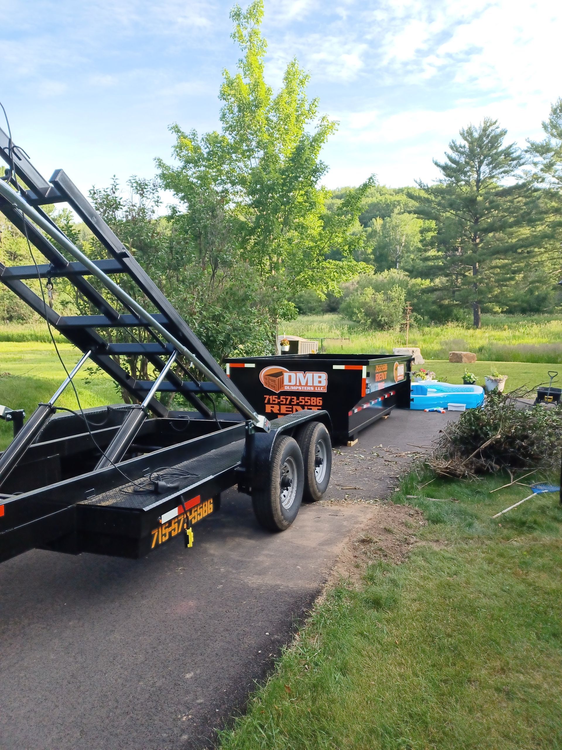 A dumpster trailer is parked on the side of the road.