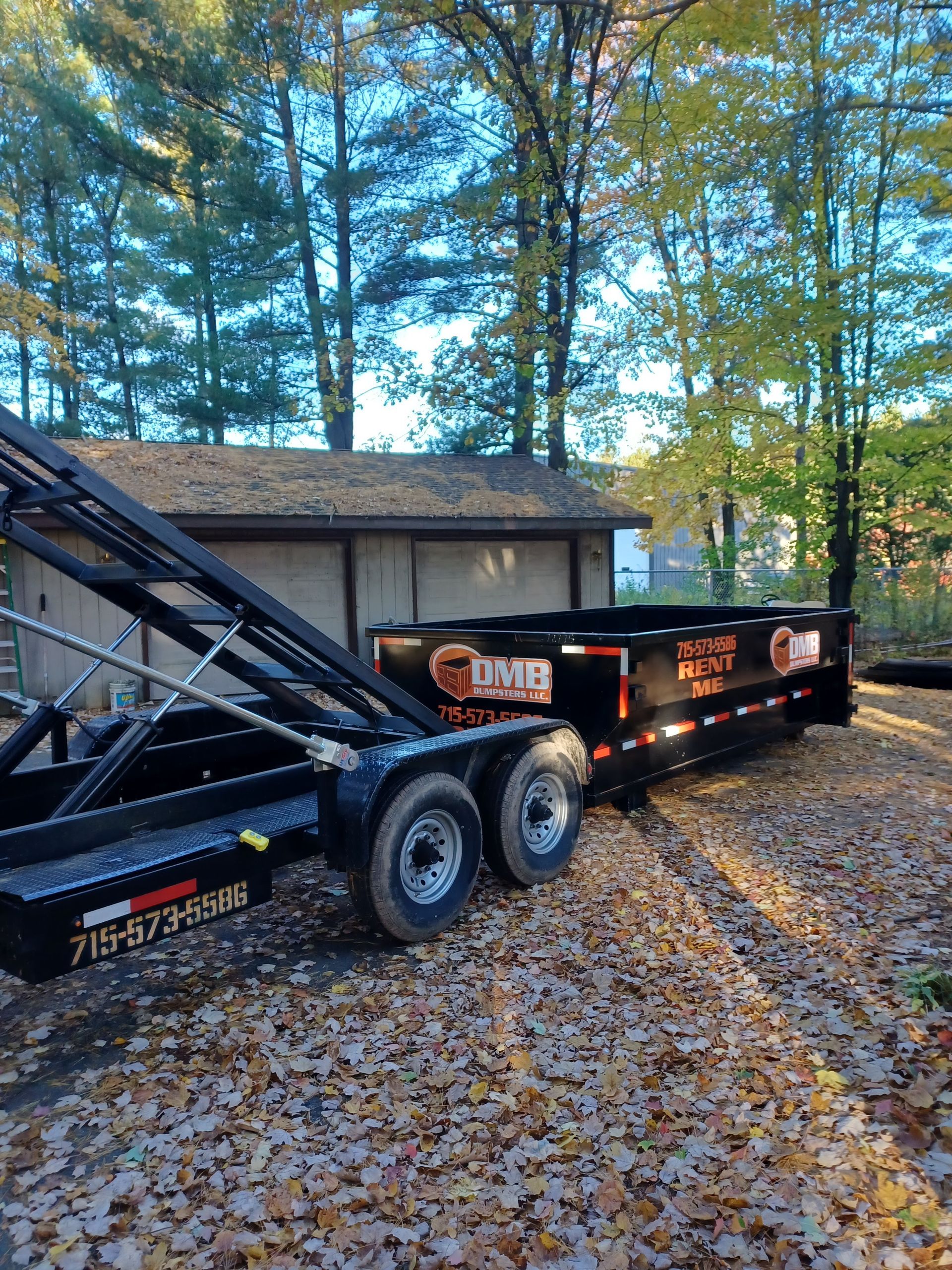 A dumpster trailer is parked in front of a house.