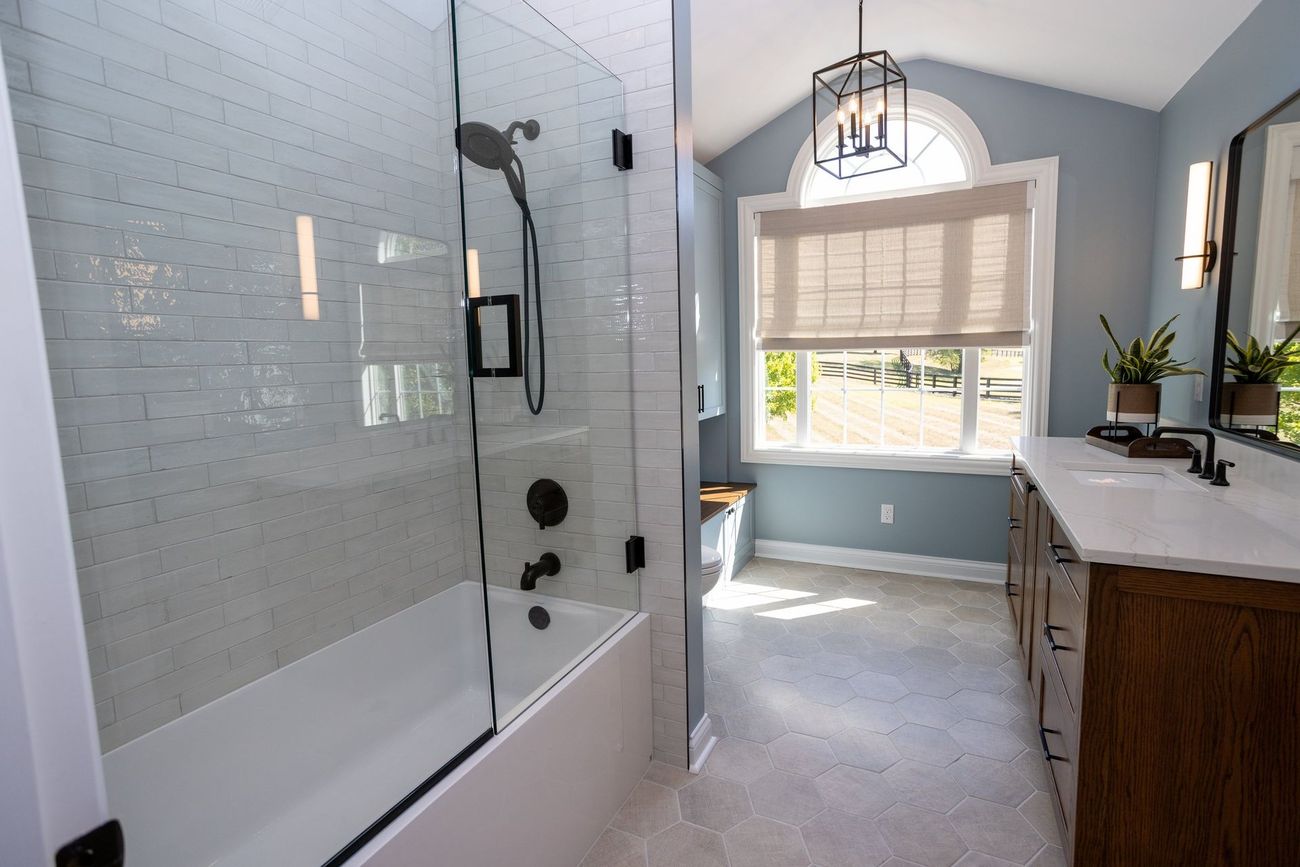 A bathroom with a bathtub , sink , and shower.