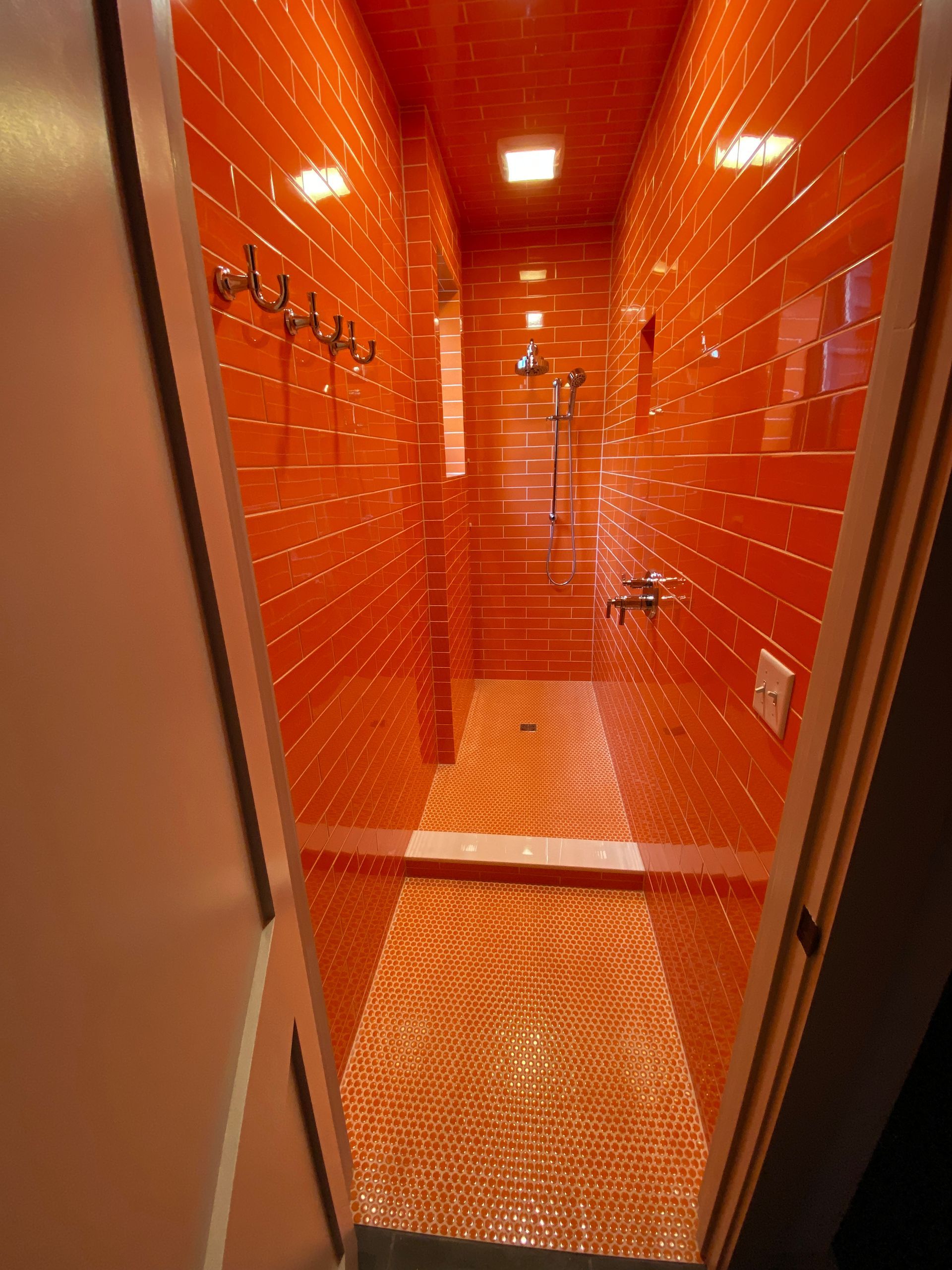 A bathroom with orange tiles and a walk in shower