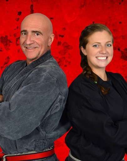 a man and a woman are standing back to back in front of a red background .