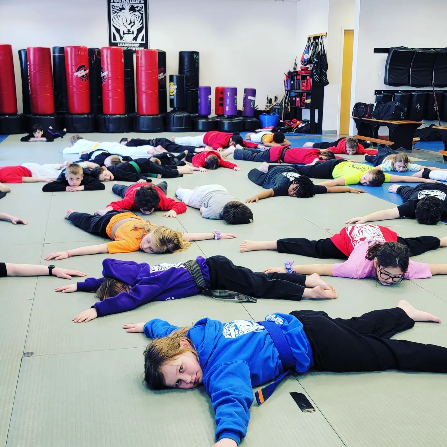 A group of children are laying on the floor in a gym