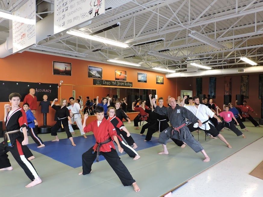 a group of people are practicing martial arts in front of a sign that says accuracy