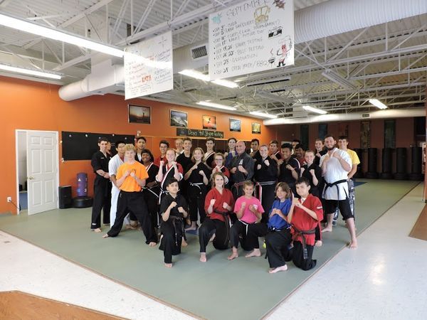 A group of people are posing for a picture in a gym