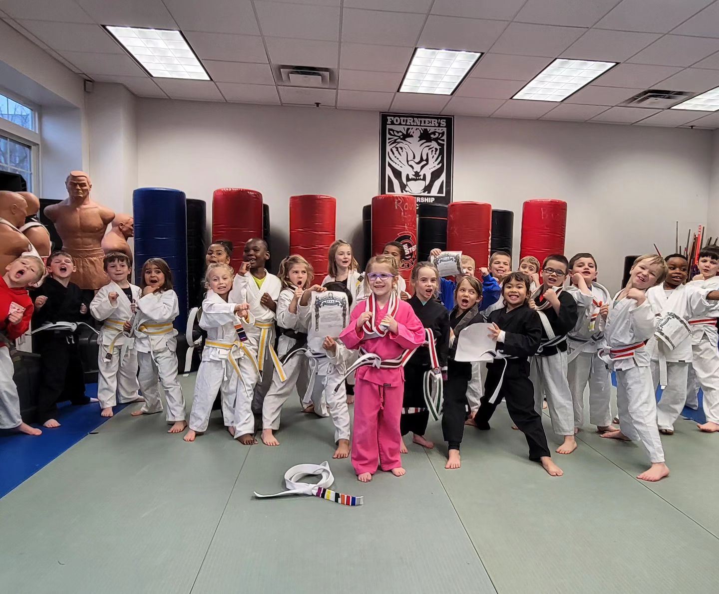 A group of children are posing for a picture in a gym.