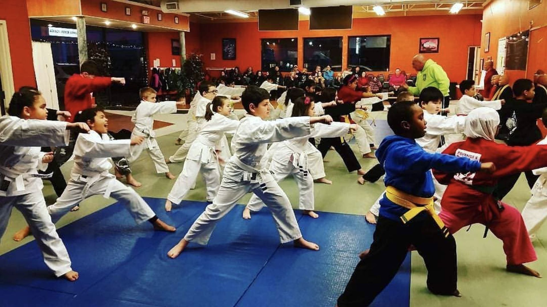 A group of children are practicing martial arts in a gym