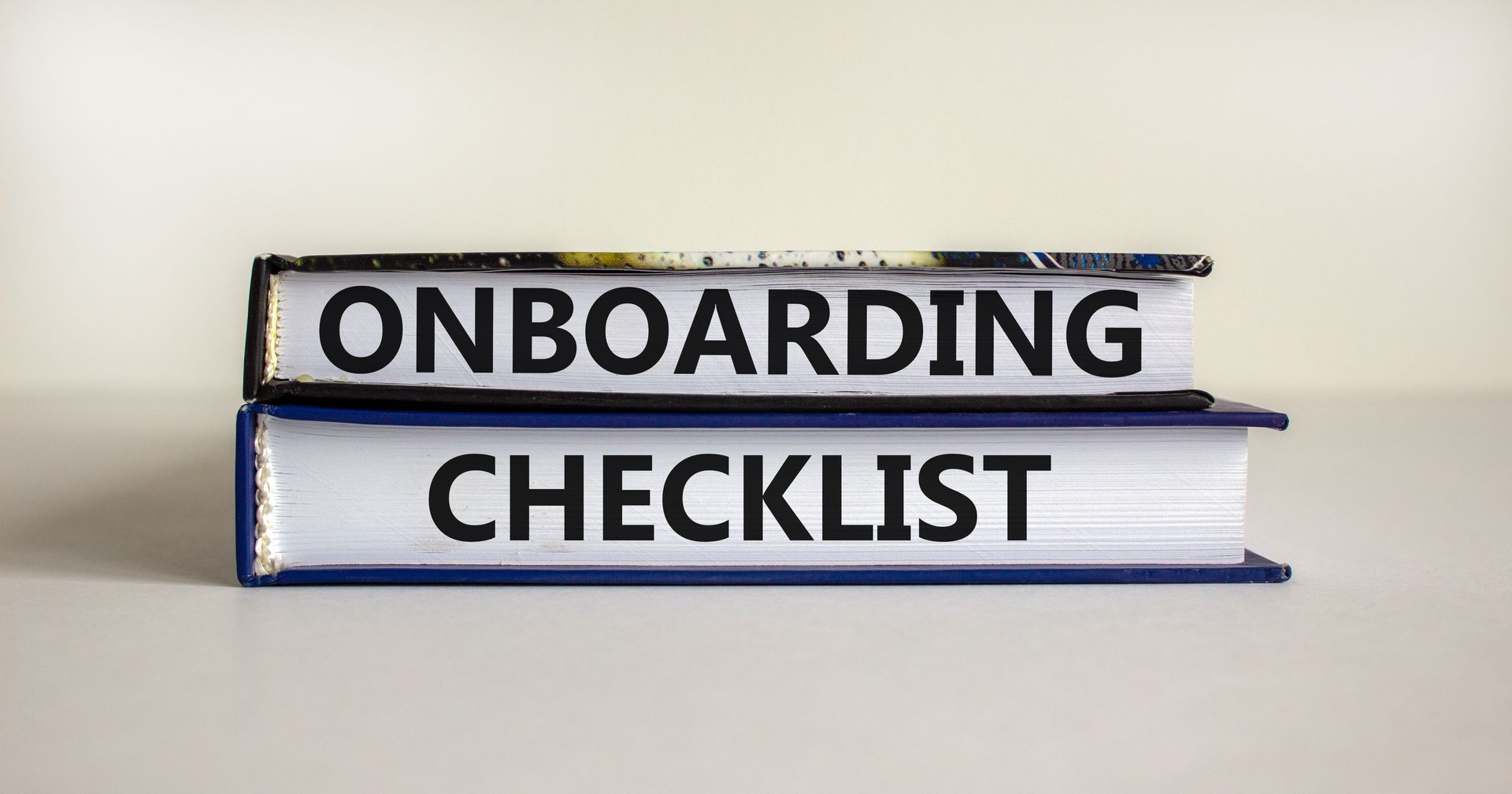 Two books stacked on top of each other with the words onboarding checklist written on them.