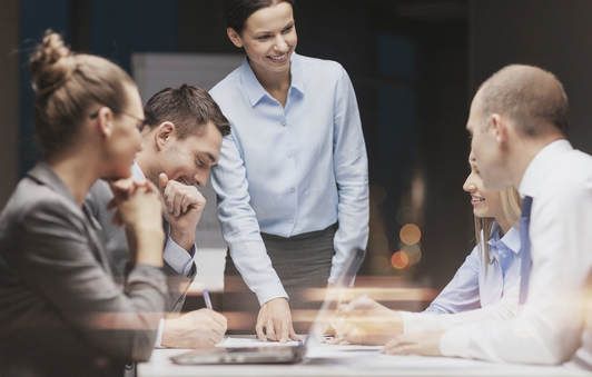 A group of people are sitting around a table having a meeting.