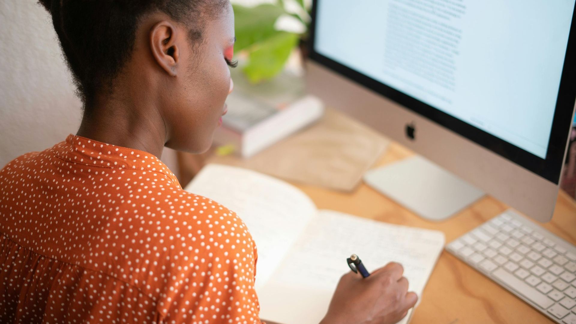 A woman is sitting at a desk in front of a computer.