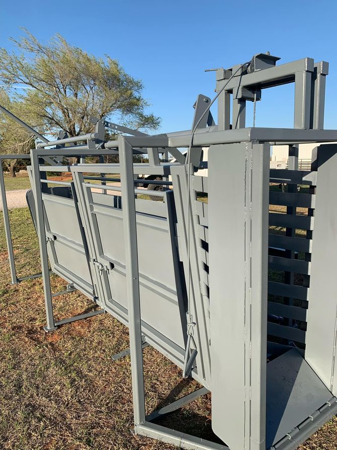 A gray metal fence is sitting on top of a pile of leaves in a field.