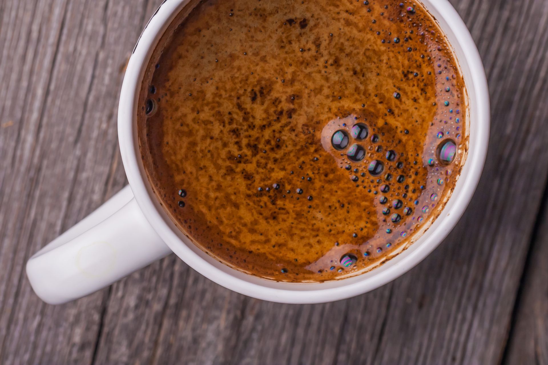 Una tazza di caffè è appoggiata su un tavolo di legno.