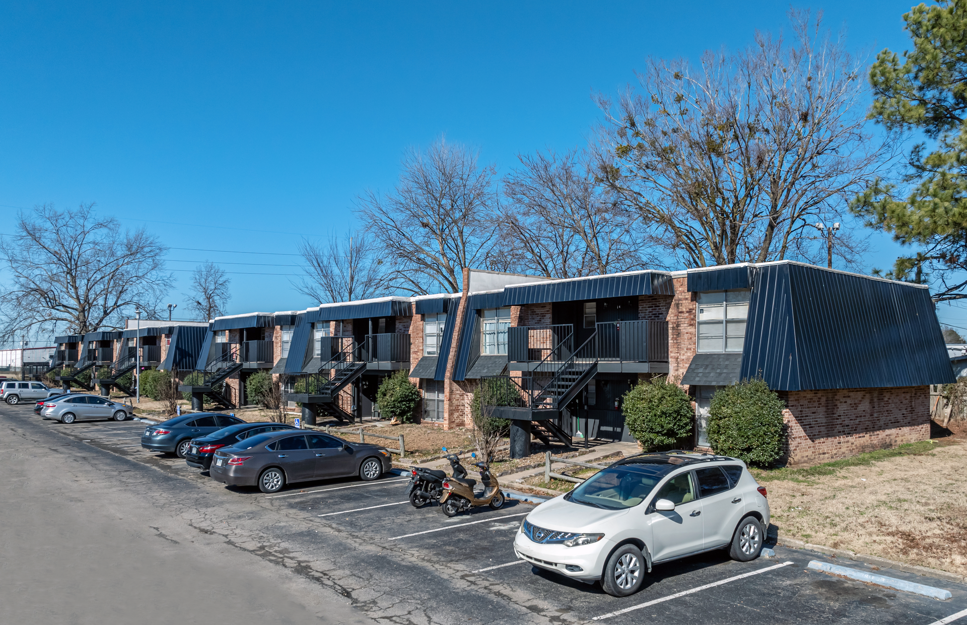 second photo showing some unit entrances, staircases and parking lot