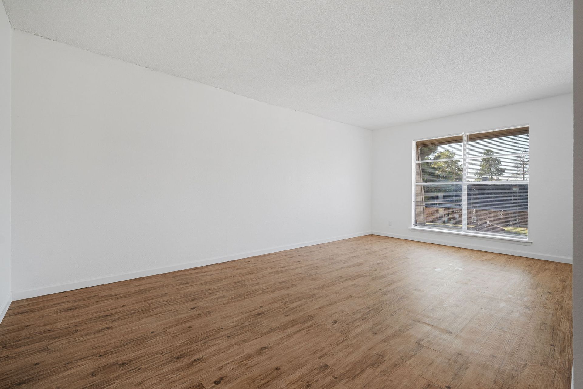 Photo showing a the length of a living room with plenty of natural light as well