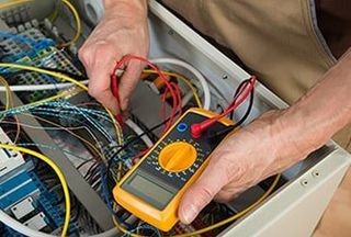 Electrician Checking A Fuse Box — Caprock Electric Inc in Lubbock, TX