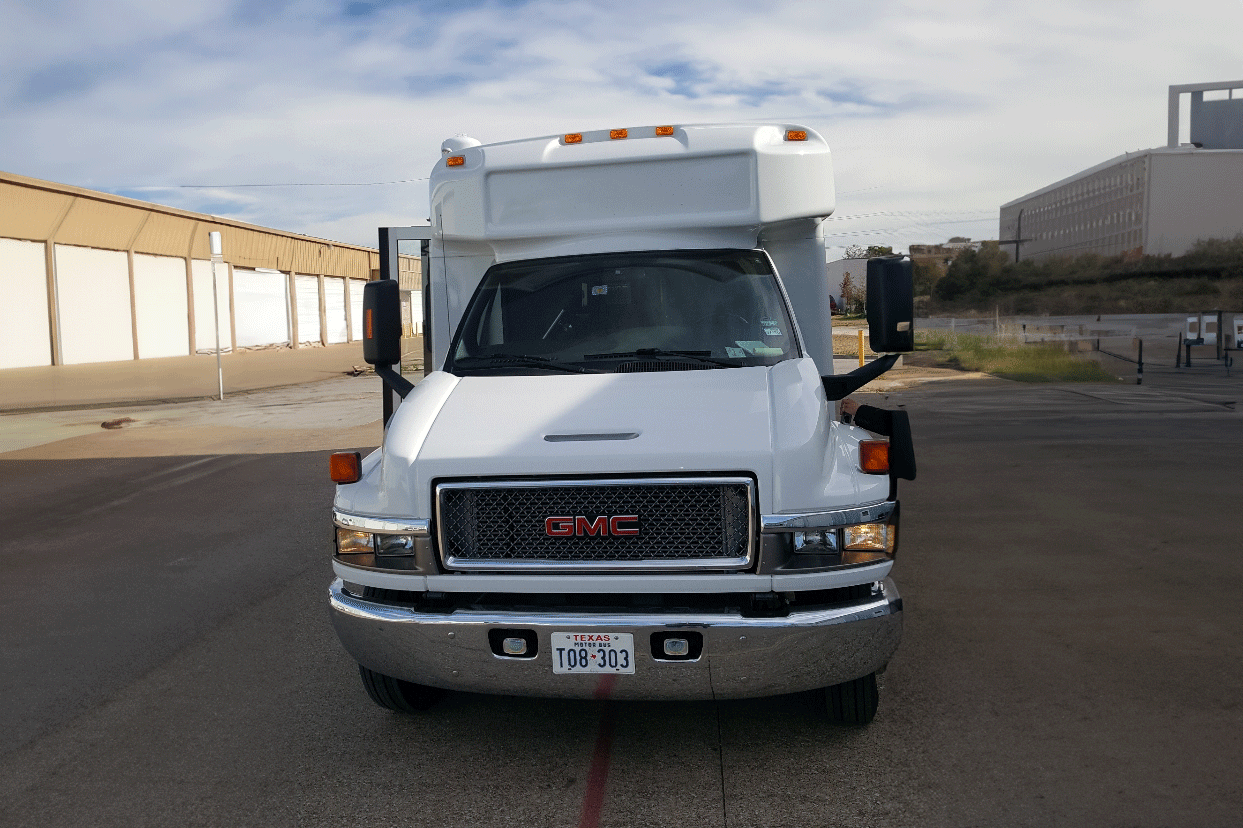 A white gmc truck is parked in a parking lot.