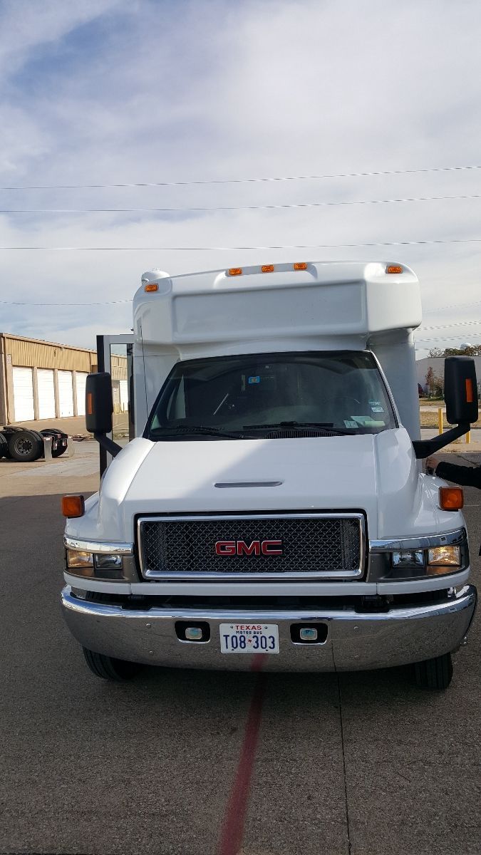 A white gmc truck is parked on the side of the road.