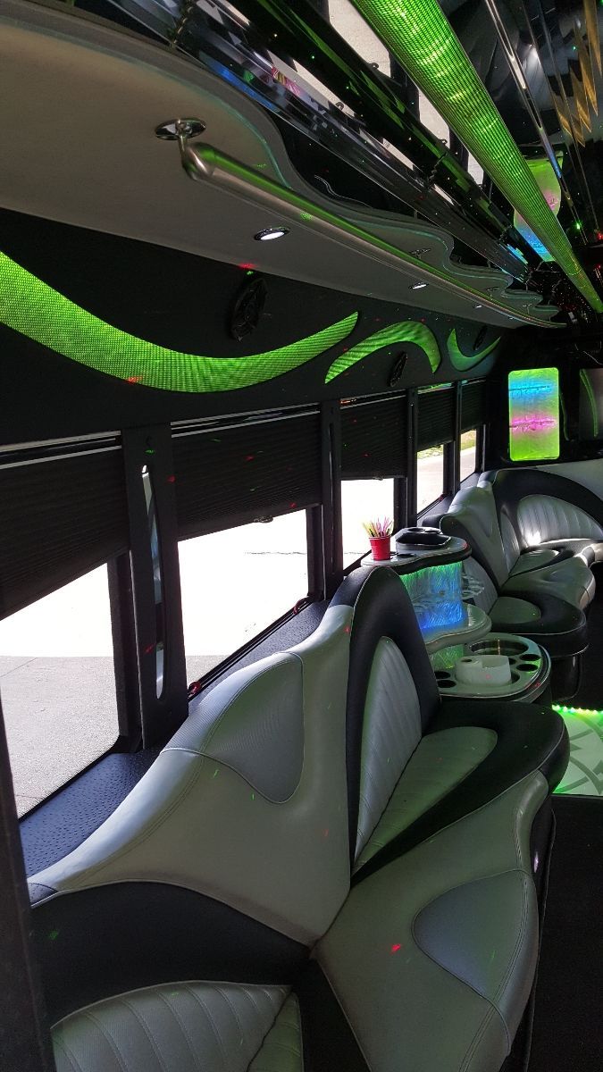 The inside of a limousine with green lights on the ceiling.