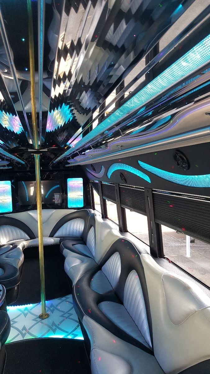 The inside of a limousine with a pole in the middle.