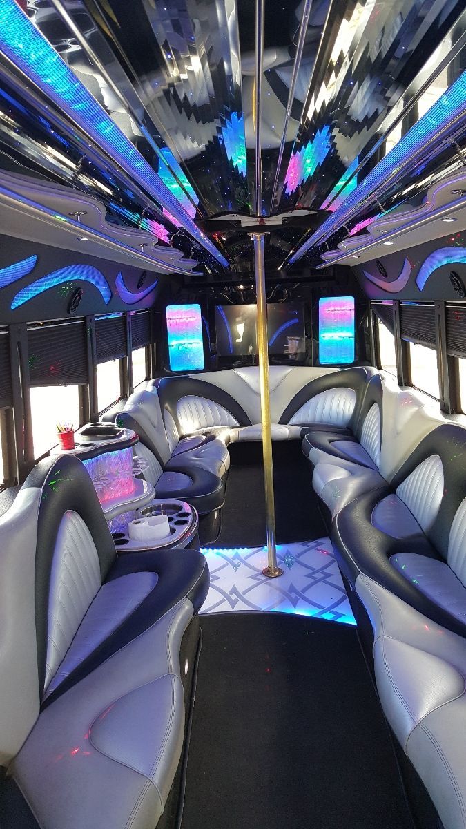 The inside of a limousine with a pole in the middle.