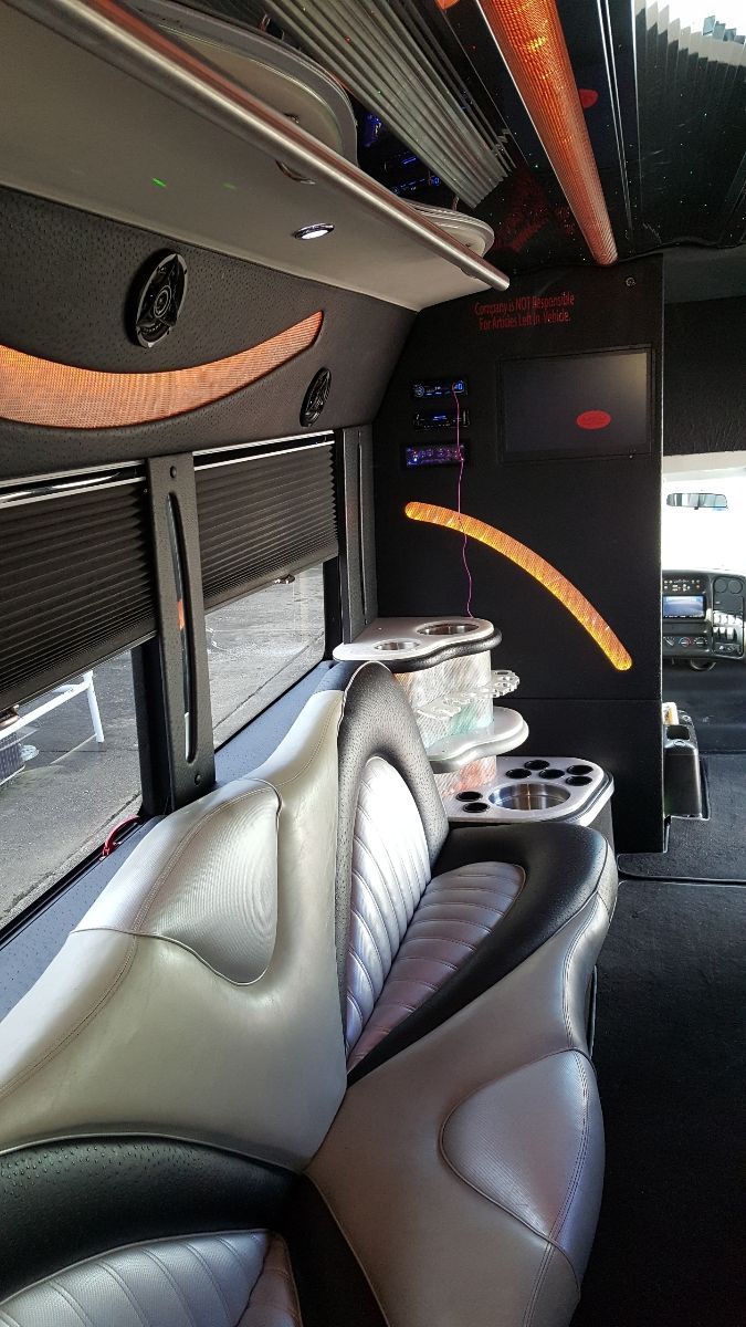 The inside of a limousine with a couch and tables.