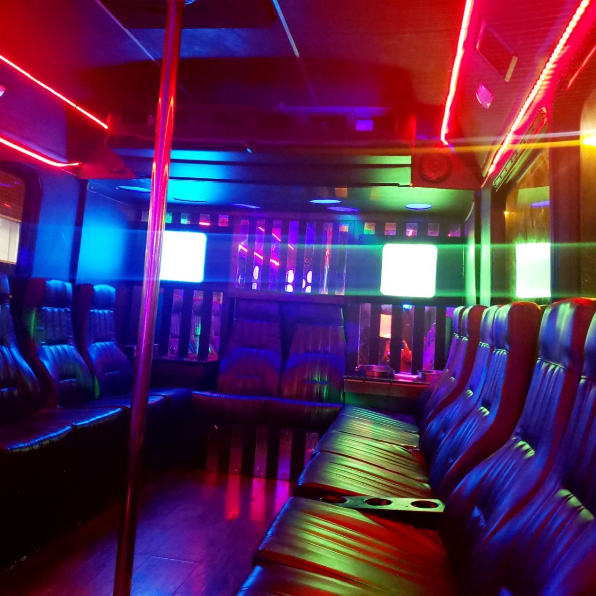 A row of seats in a dark room with neon lights