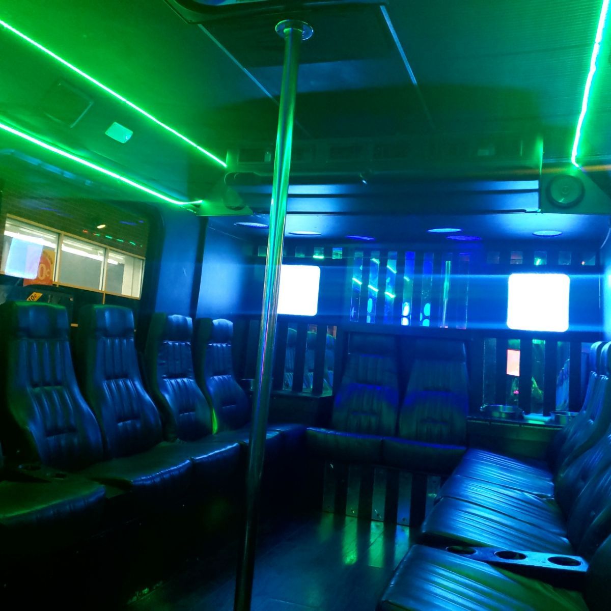 The inside of a bus with green lights on the ceiling