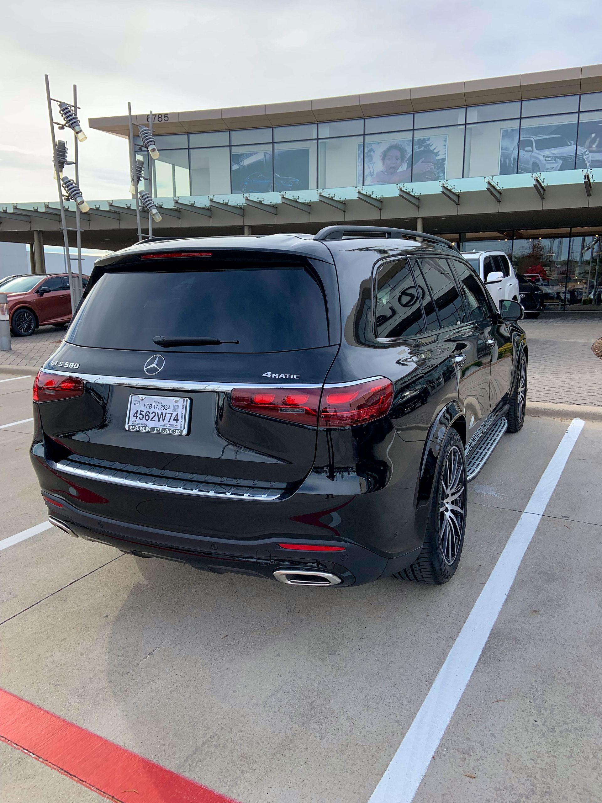 A black suv is parked in a parking lot in front of a building.