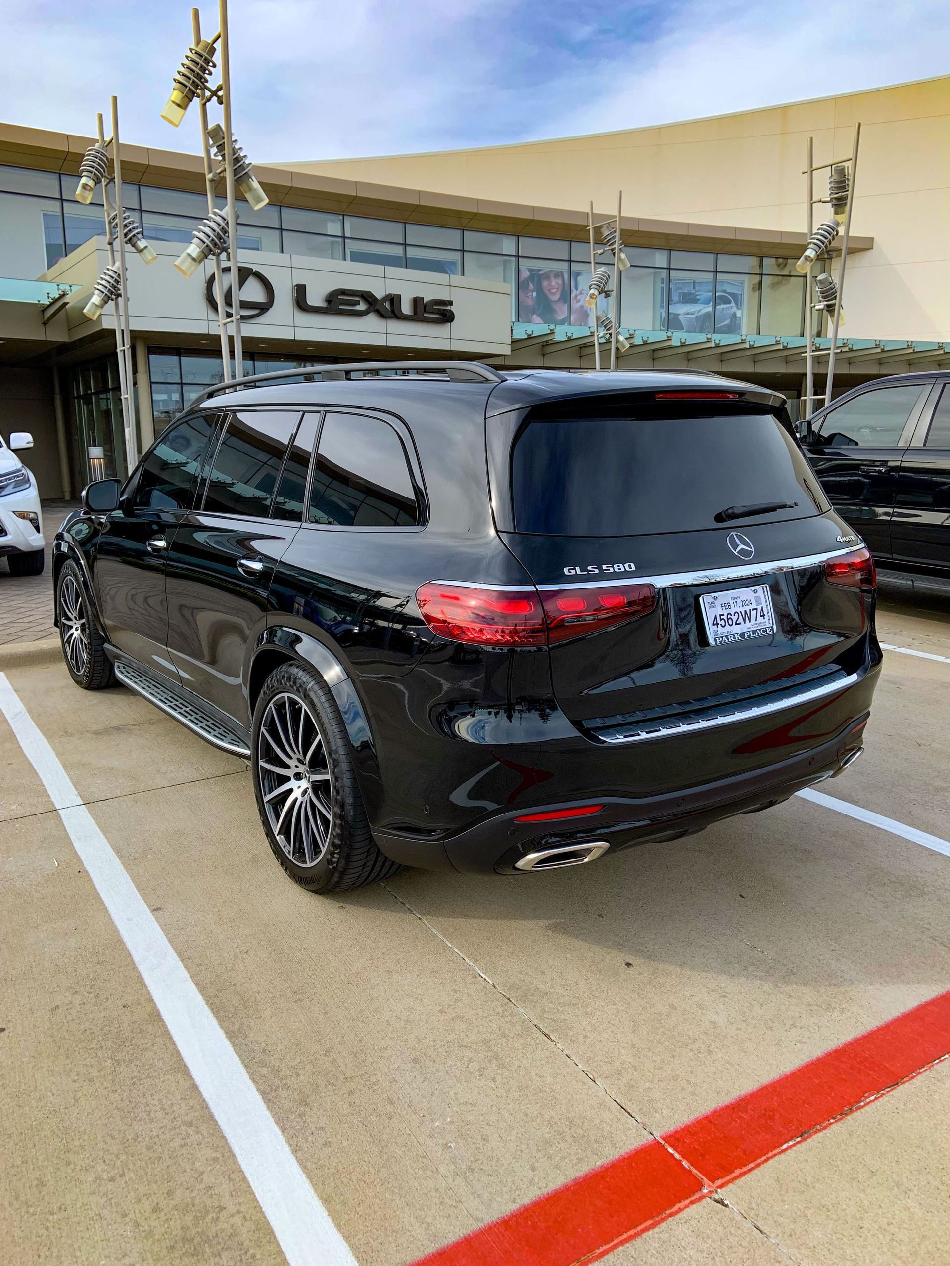 A black suv is parked in a parking lot in front of a building.