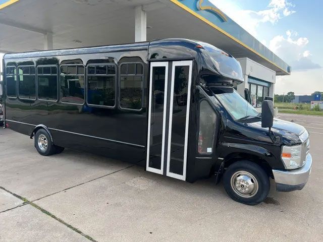 A black van is parked in a garage with the door open