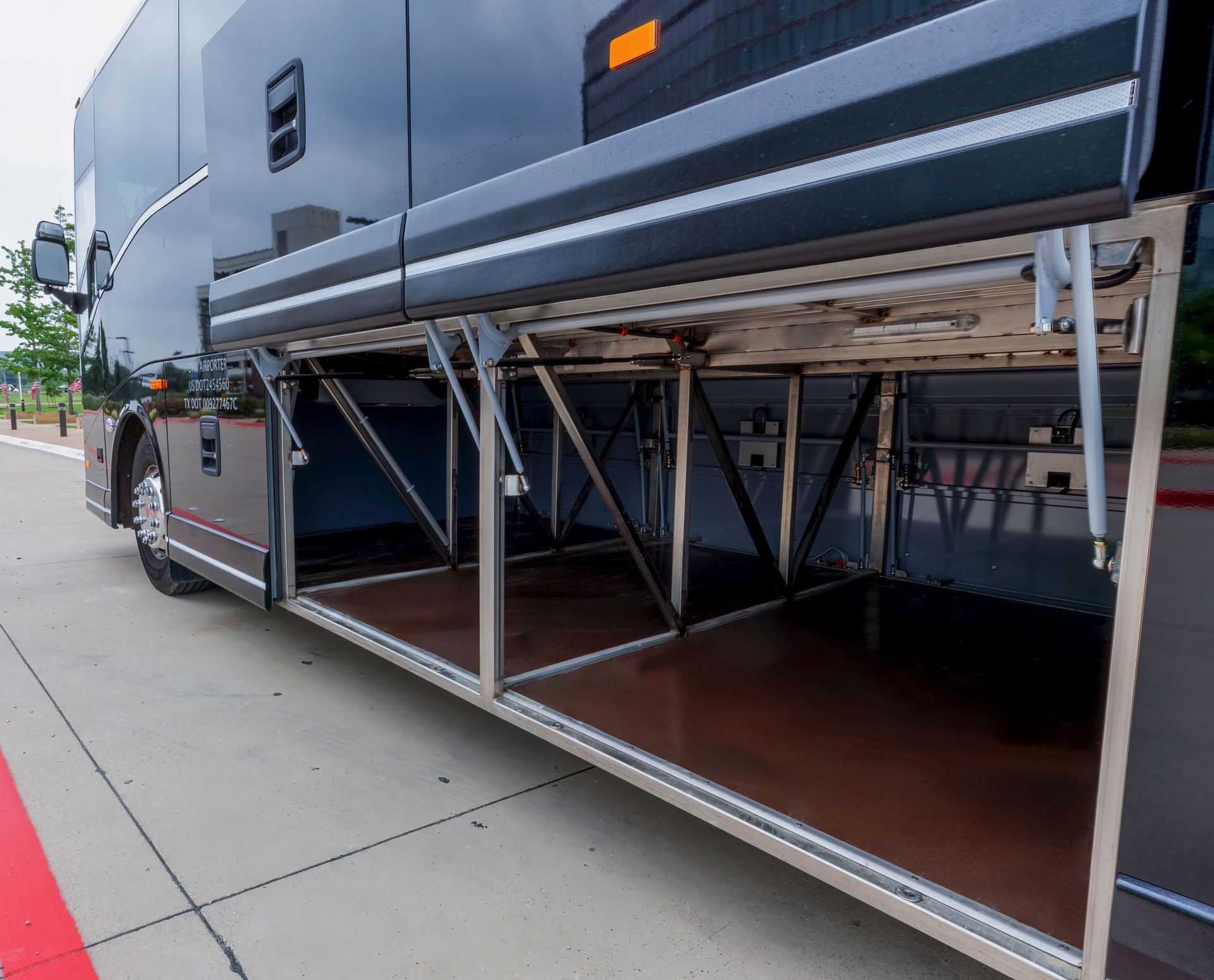 The trunk of a bus is open and has a wooden floor.