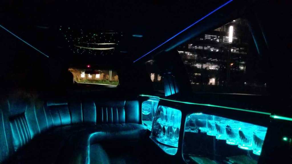 The inside of a limousine is lit up with blue lights.