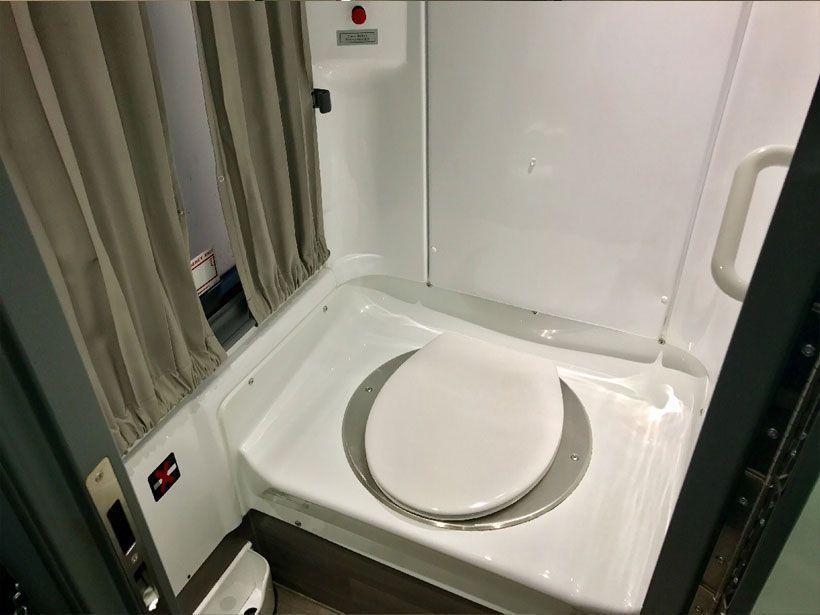A white toilet with a round seat in a bathroom