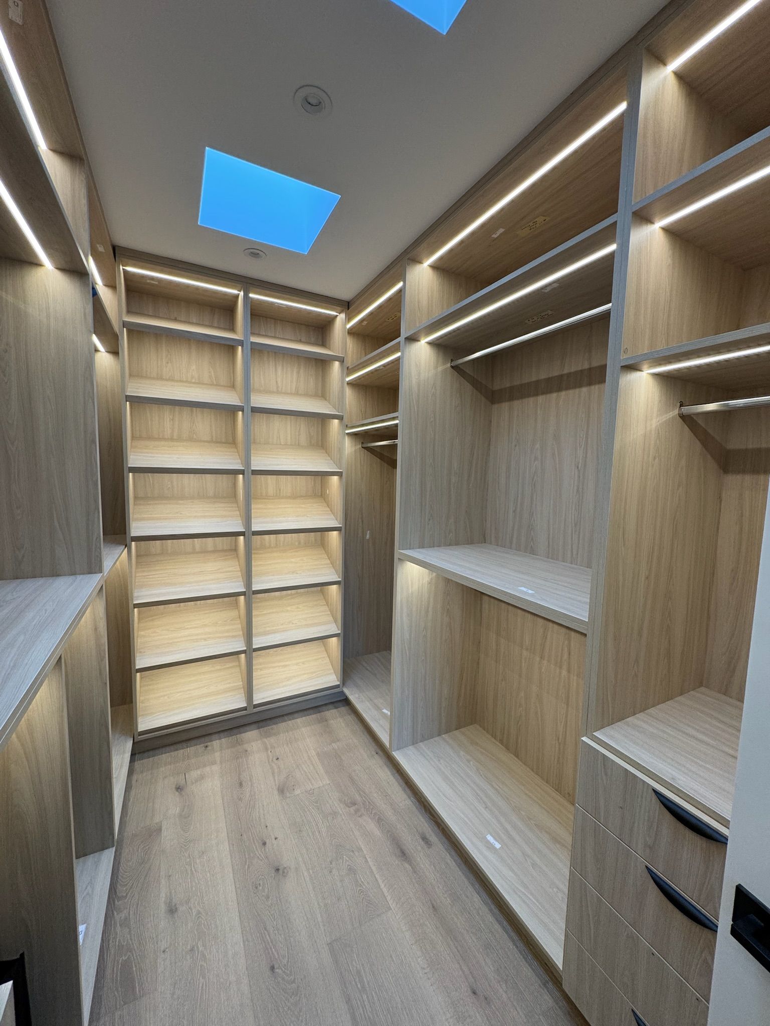 A small, narrow bathroom with a decorative mirror and a wooden sink.