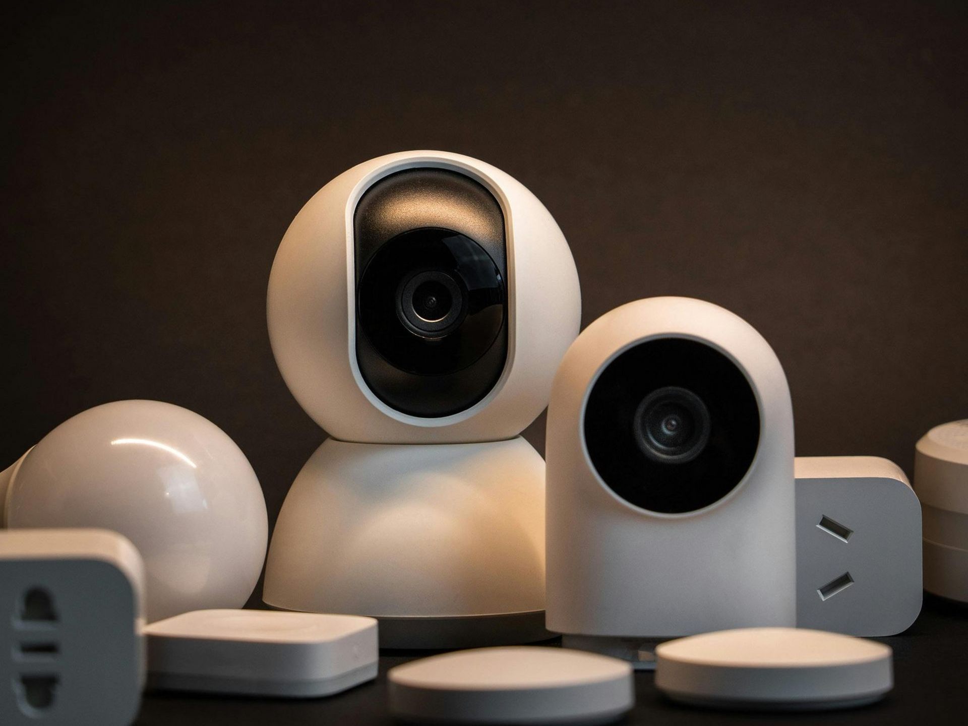 White security cameras and smart home devices against a dark background.