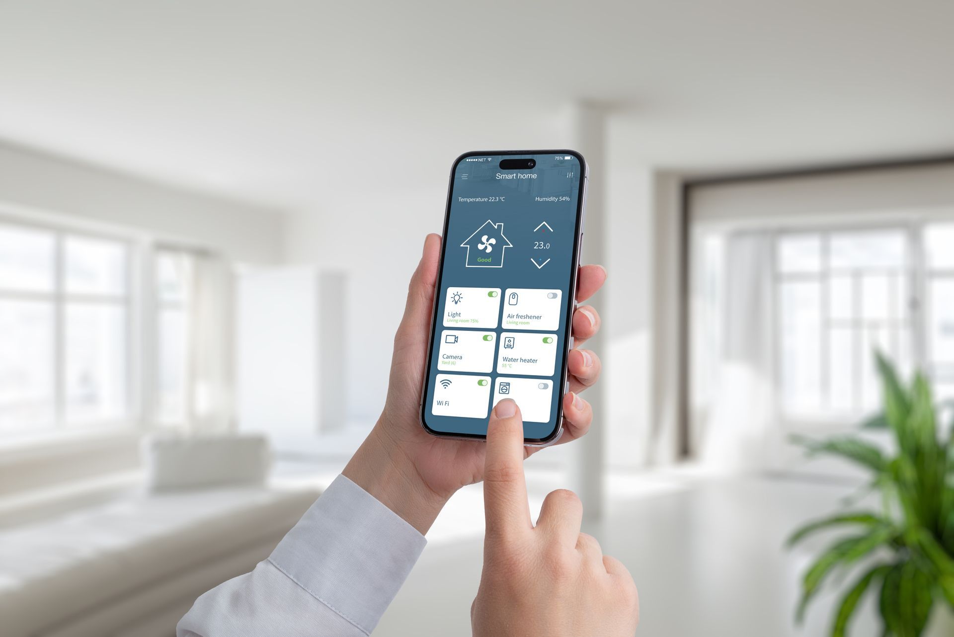 Person holding smartphone, using smart home app in a living room, with controls for lights and climate.