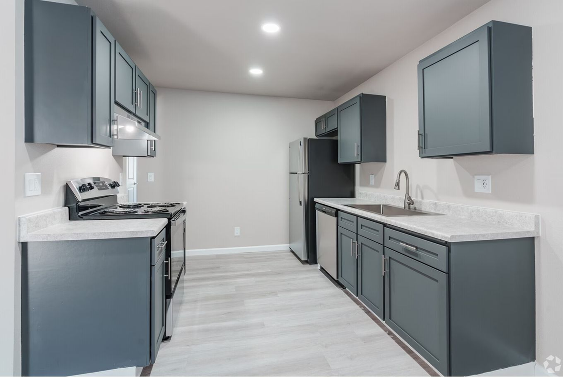 Gray kitchen with matching cabinets, light countertops, and stainless steel appliances.