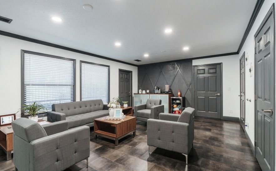 Round wooden coffee table with a decorative plant and basket in a living room.