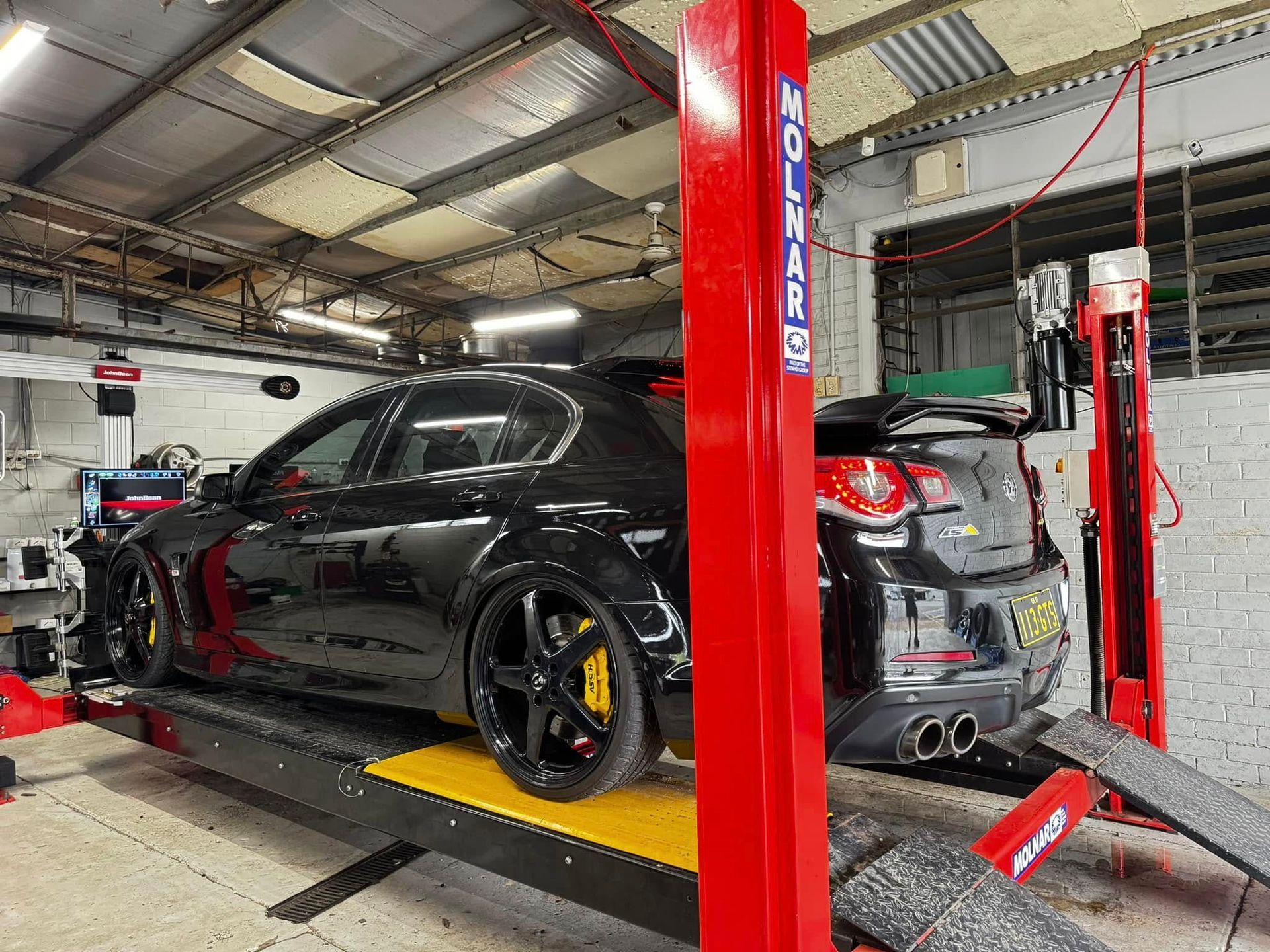 A Black Car on A Lift in A Workshop — Jakes Tyres in South Murwillumbah, NSW
