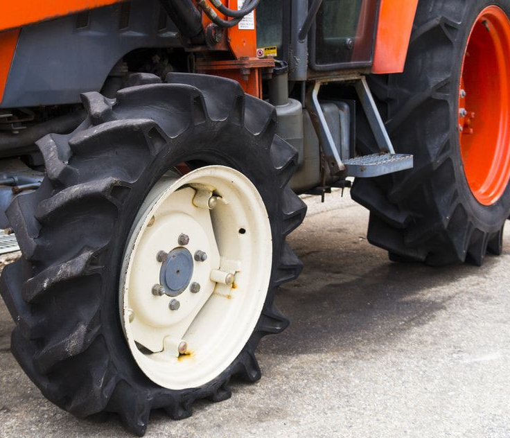 Orange tractor with a large black tire and a white wheel. Jakes Tyres in South Murwillumbah, NSW
