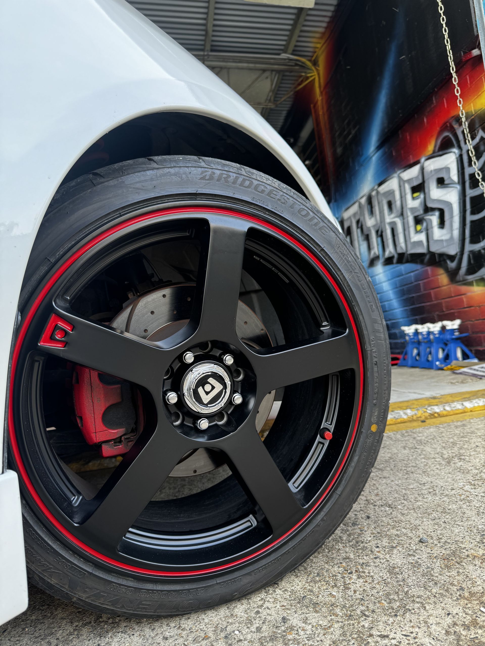 A Car Wheel with Red Rim and Brake Caliper — Jakes Tyres in South Murwillumbah, NSW