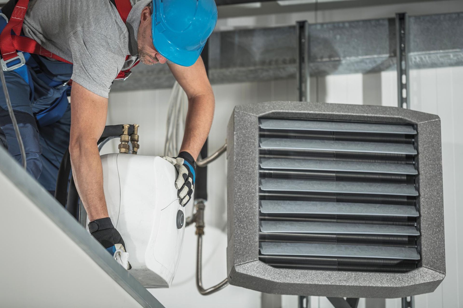 A man is working on a heater in a building.