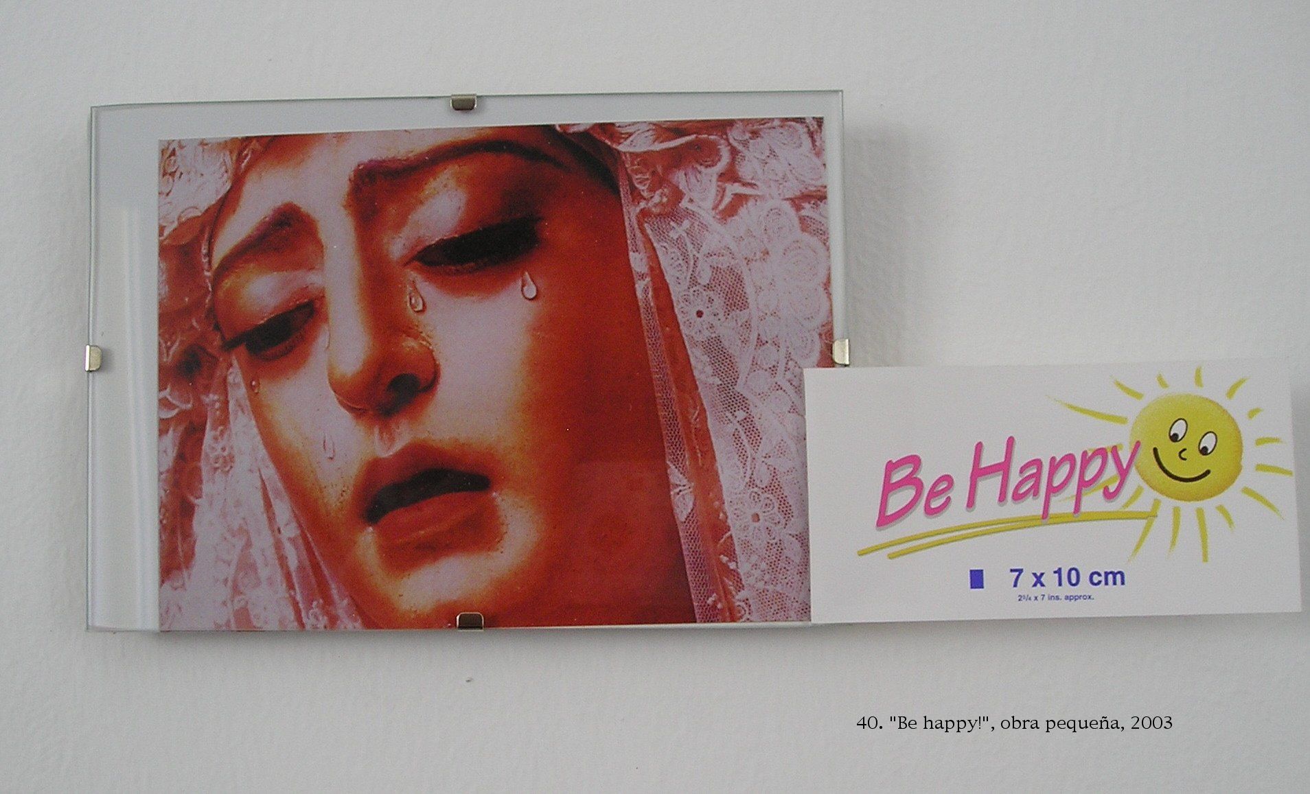 Ein Bild einer weinenden Frau neben einem Schild mit der Aufschrift „Sei glücklich“