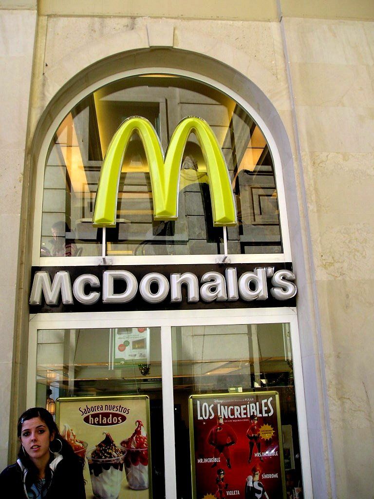 Eine Frau steht vor einem McDonald's-Restaurant