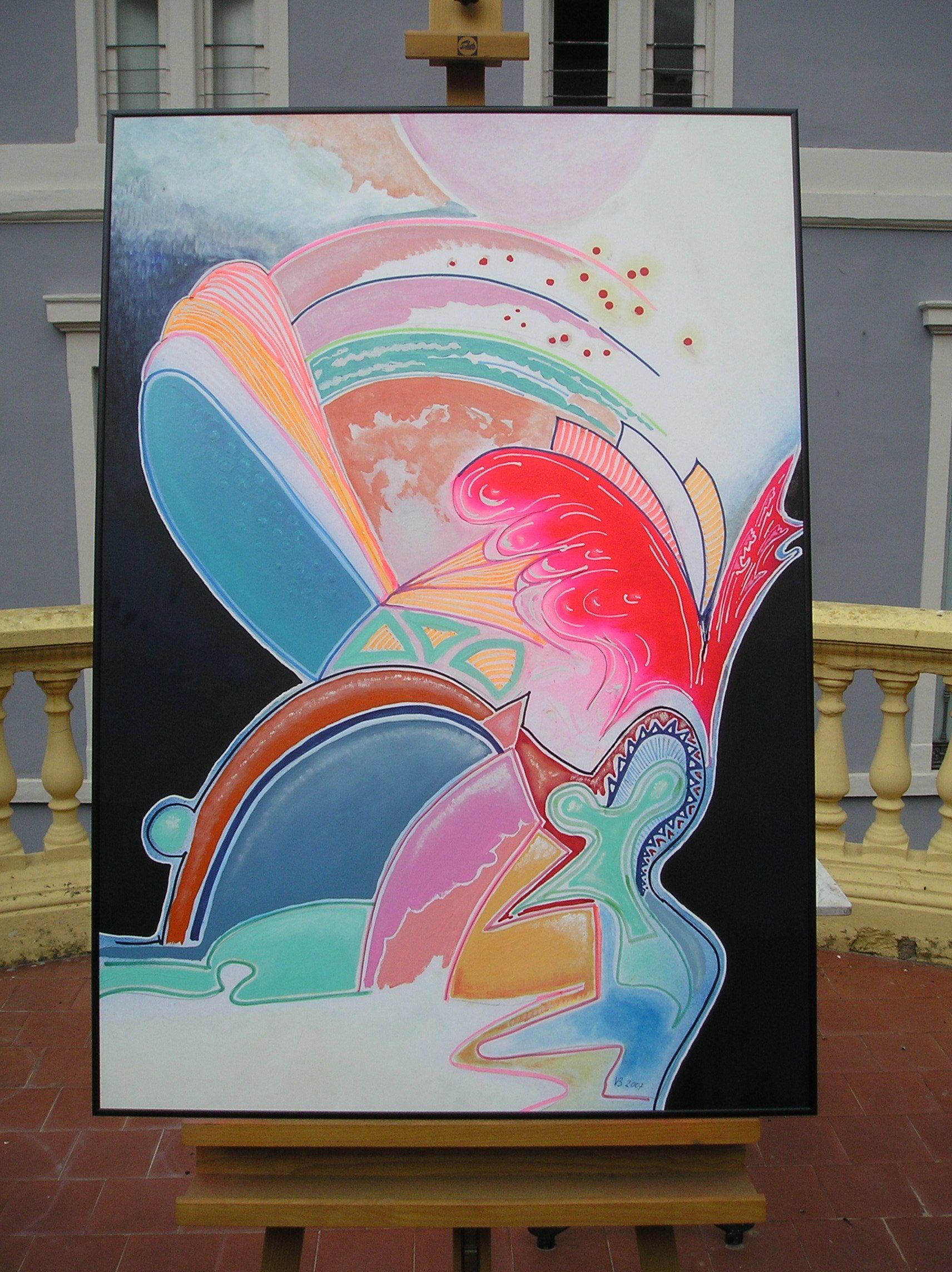 Ein farbenfrohes Gemälde steht auf einer Staffelei vor einem Gebäude