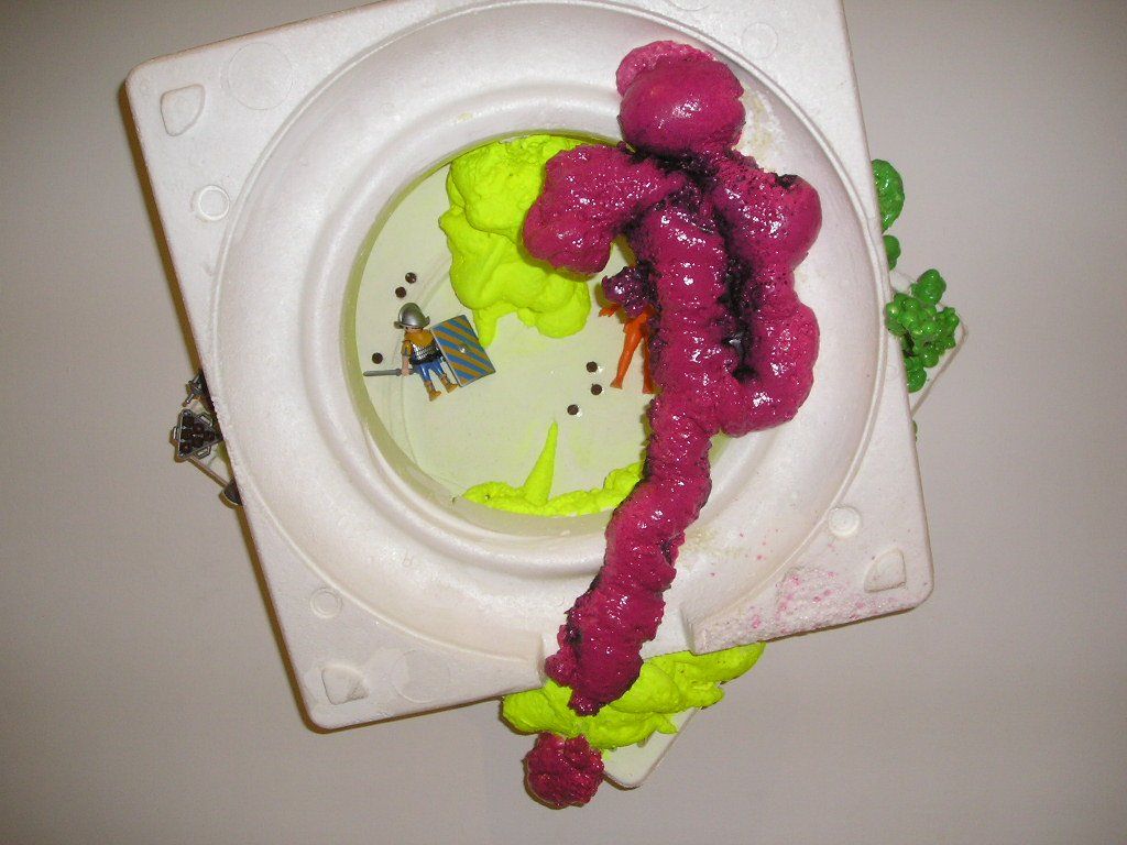 Ein weißer Teller mit violettem und gelbem Schaum darauf