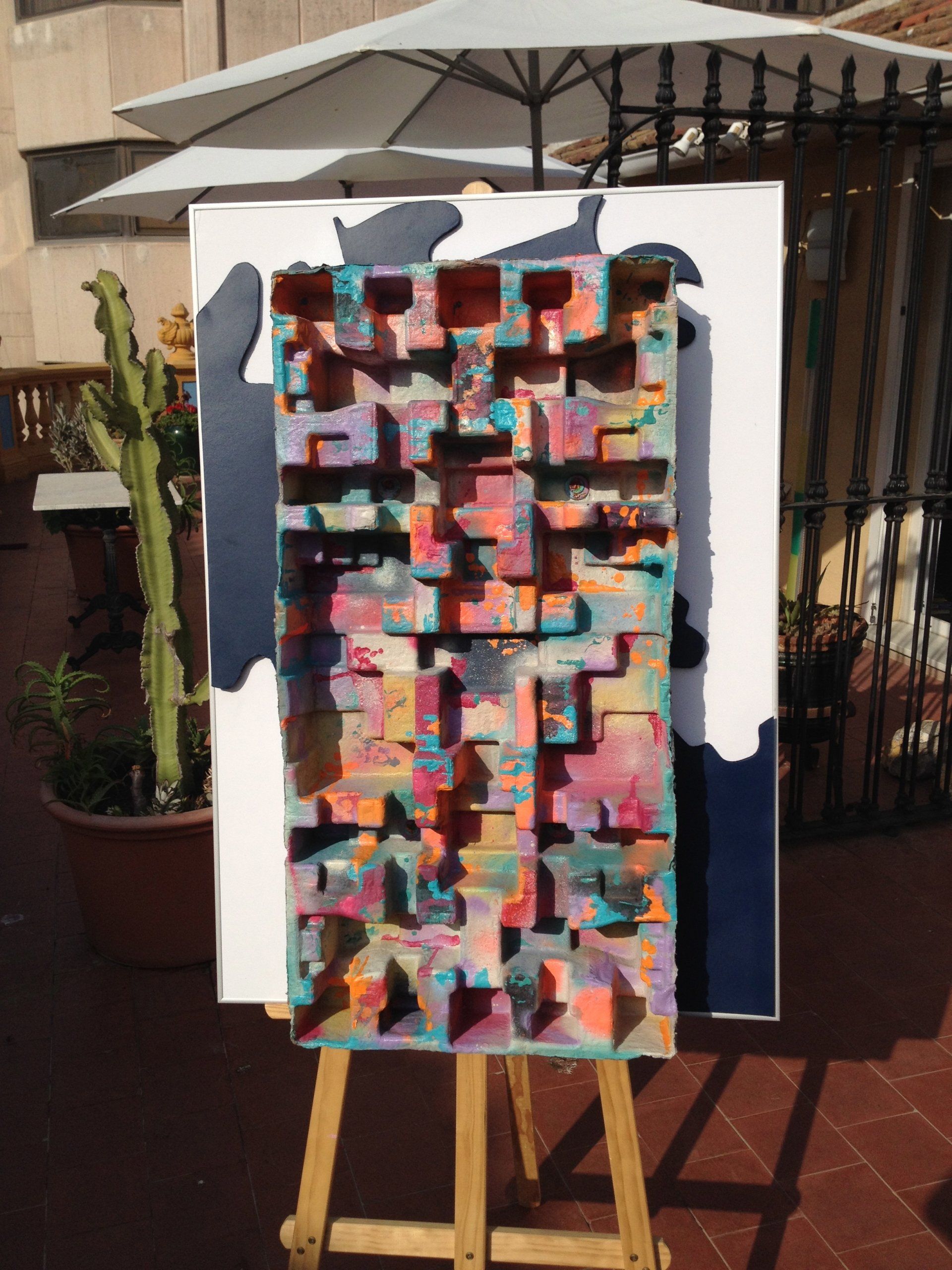 Auf einer hölzernen Staffelei wird ein farbenfrohes Gemälde ausgestellt