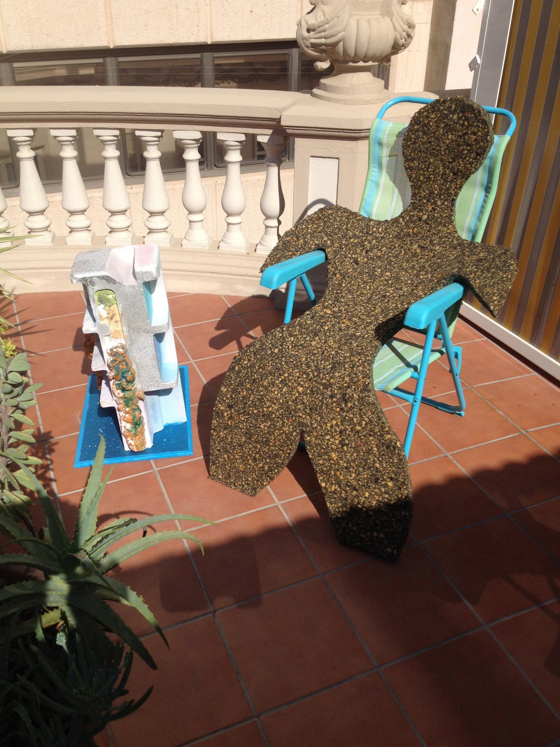 Eine Statue einer Schildkröte sitzt auf einer Terrasse neben einem Stuhl